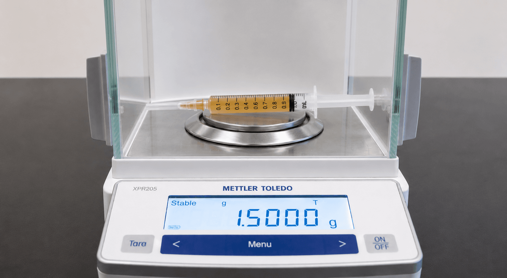 Weighing balance with syringe